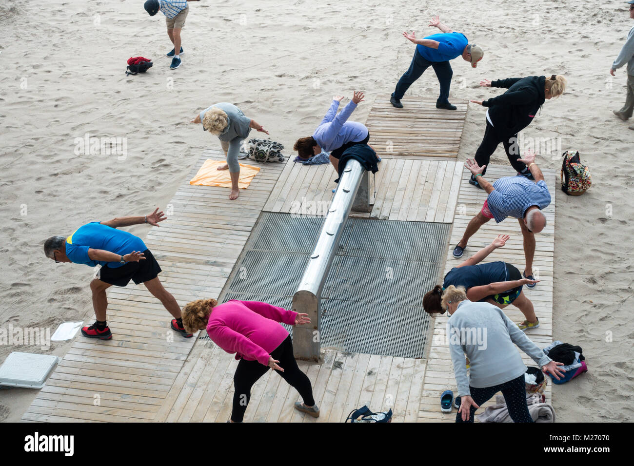 Los ancianos mantenerse en forma en la playa de Benidorm, España. Hombres, mujeres, ancianos del pensionista, clase de gimnasia Foto de stock