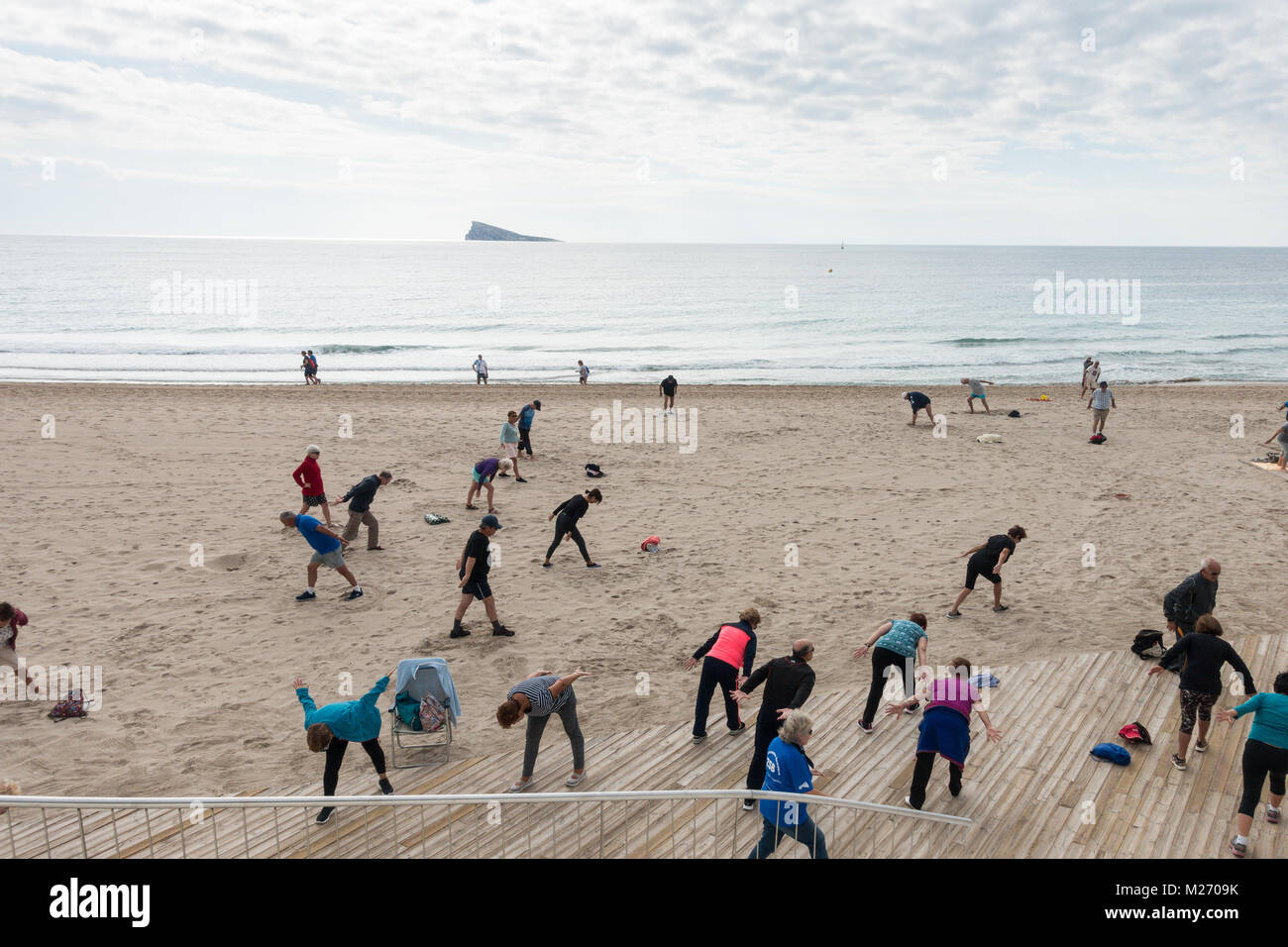 Los ancianos mantenerse en forma en la playa de Benidorm, España. Hombres, mujeres, ancianos del pensionista, clase de gimnasia Foto de stock