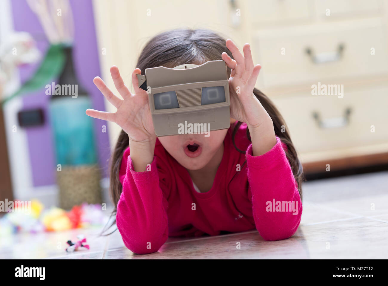 Niña juega con un viejo visor 3D Foto de stock