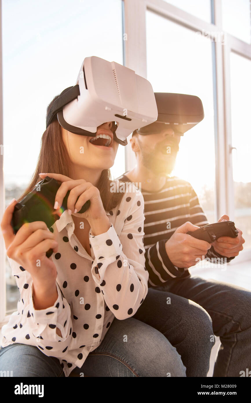 Sobresaltado hermosa mujer iniciar juego VR Foto de stock
