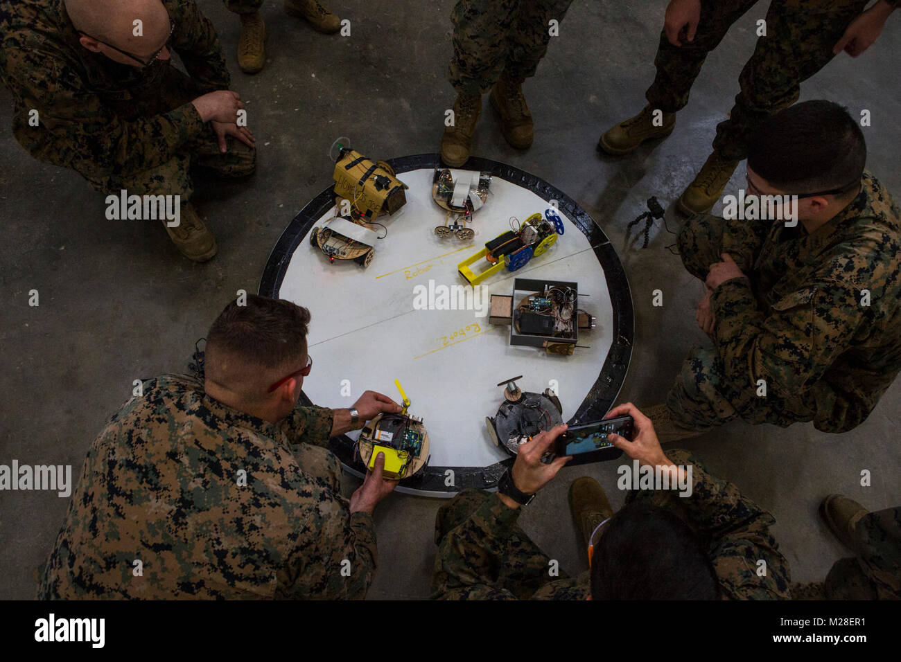 Los Marines de EE.UU. asistir a un curso de creador de Marina se reúnen  alrededor de los combates de anillo y coloque sus robots en el interior  para una batalla real en