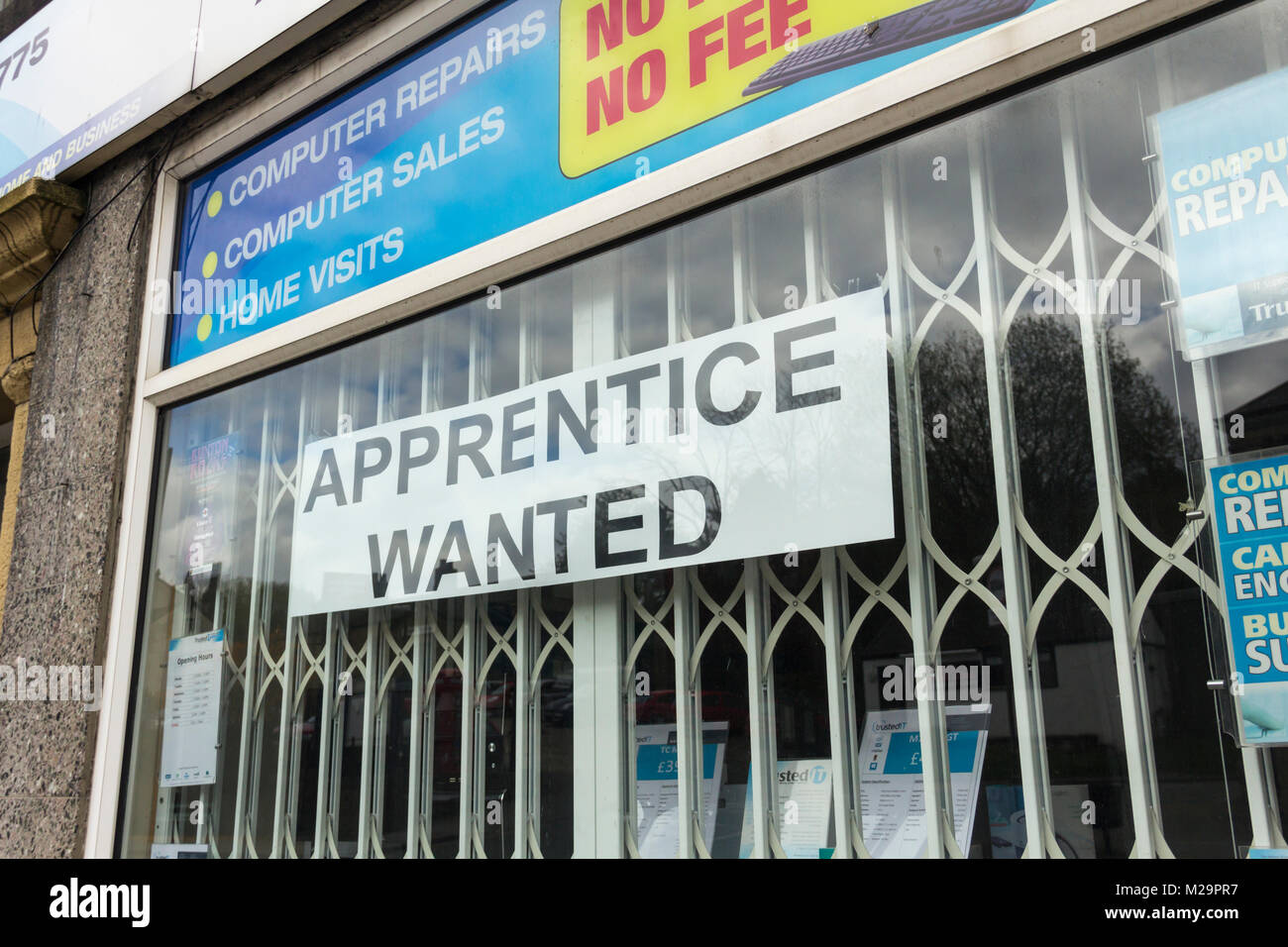 'Aprendiz quería', un gran signo de banner en el escaparate de un local de venta y reparación de computadoras shop (Confianza) en la calle Market, Whaley Bridge. Foto de stock