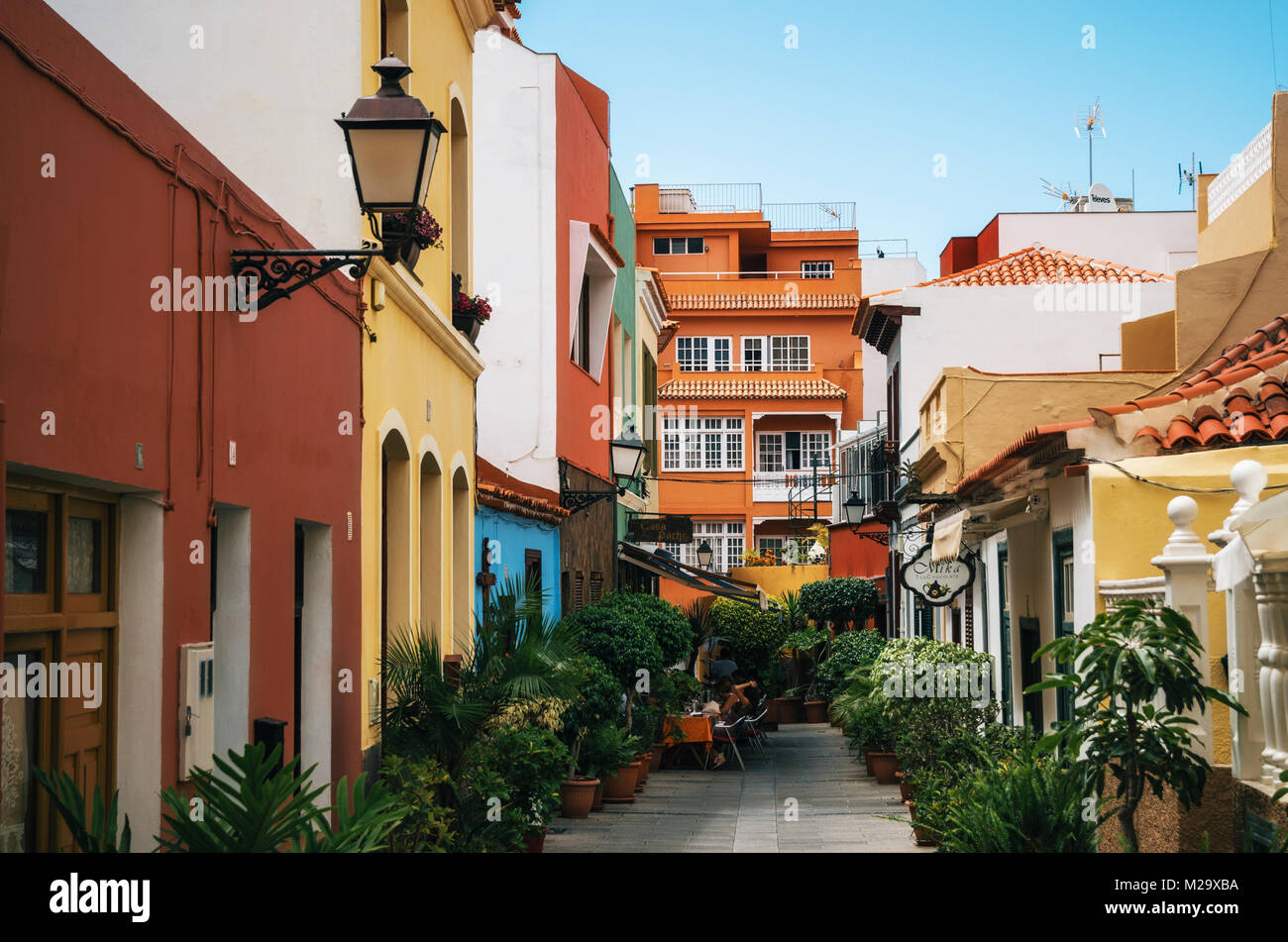 Puerto de la Cruz, Tenerife, Islas Canarias - Mayo 30, 2017: calle angosta en la ciudad con coloridas casas de estilo retro, cafeterías y zonas verdes,de la isla de Tenerife, Cana. Foto de stock