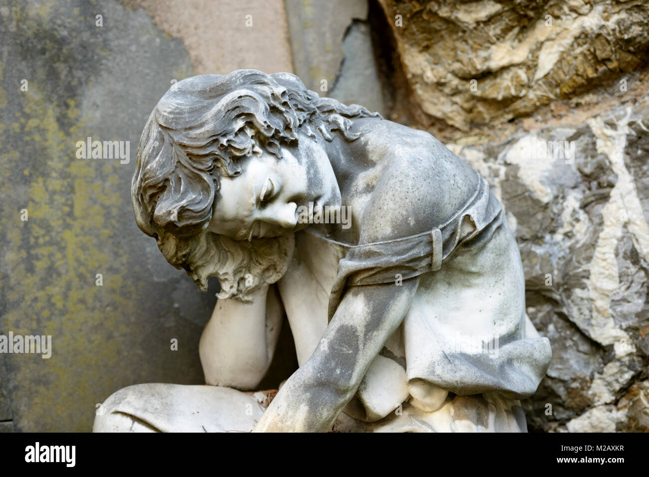 La escultura de piedra de la mujer que sufre en el cementerio monumental de Staglieno histórico en la ciudad, rodada en la brillante luz de invierno en Genova, Liguria, Italia Foto de stock