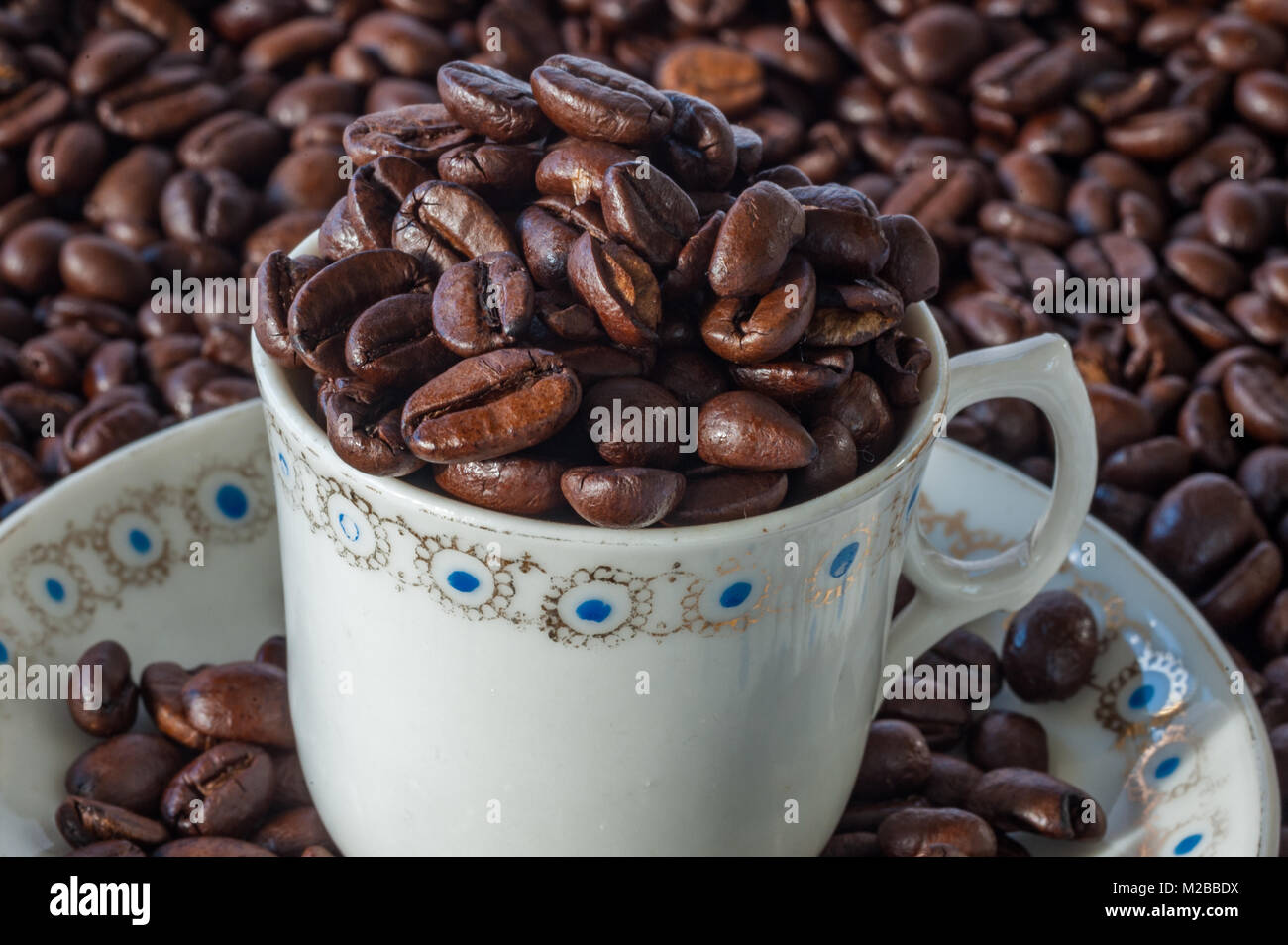 Taza y plato lleno de granos de café en un café espresso antecedentes concepto con copia espacio cercano. Foto de stock
