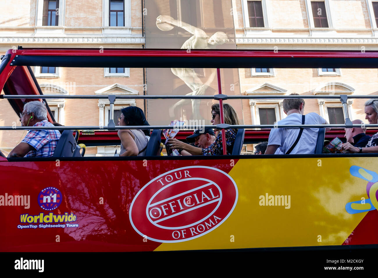 Recorrido turístico de autobuses rojos de dos pisos, pasando por delante del Palazzo Massimo alle Terme, Museo Nacional Romano. Banner con discobolus. Roma, Italia Foto de stock