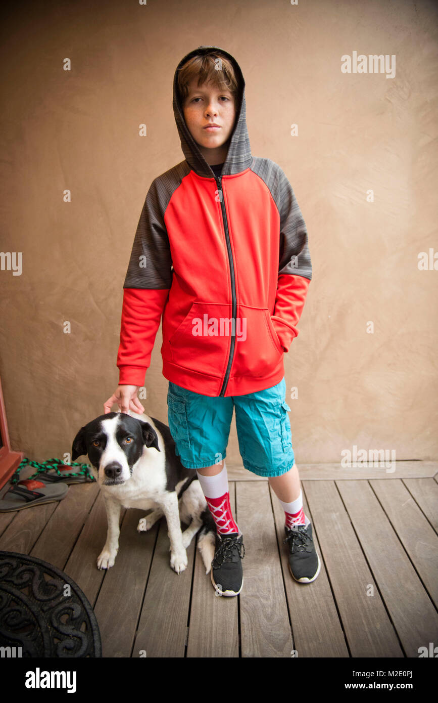 Retrato de niño caucásico de pie con perro Foto de stock