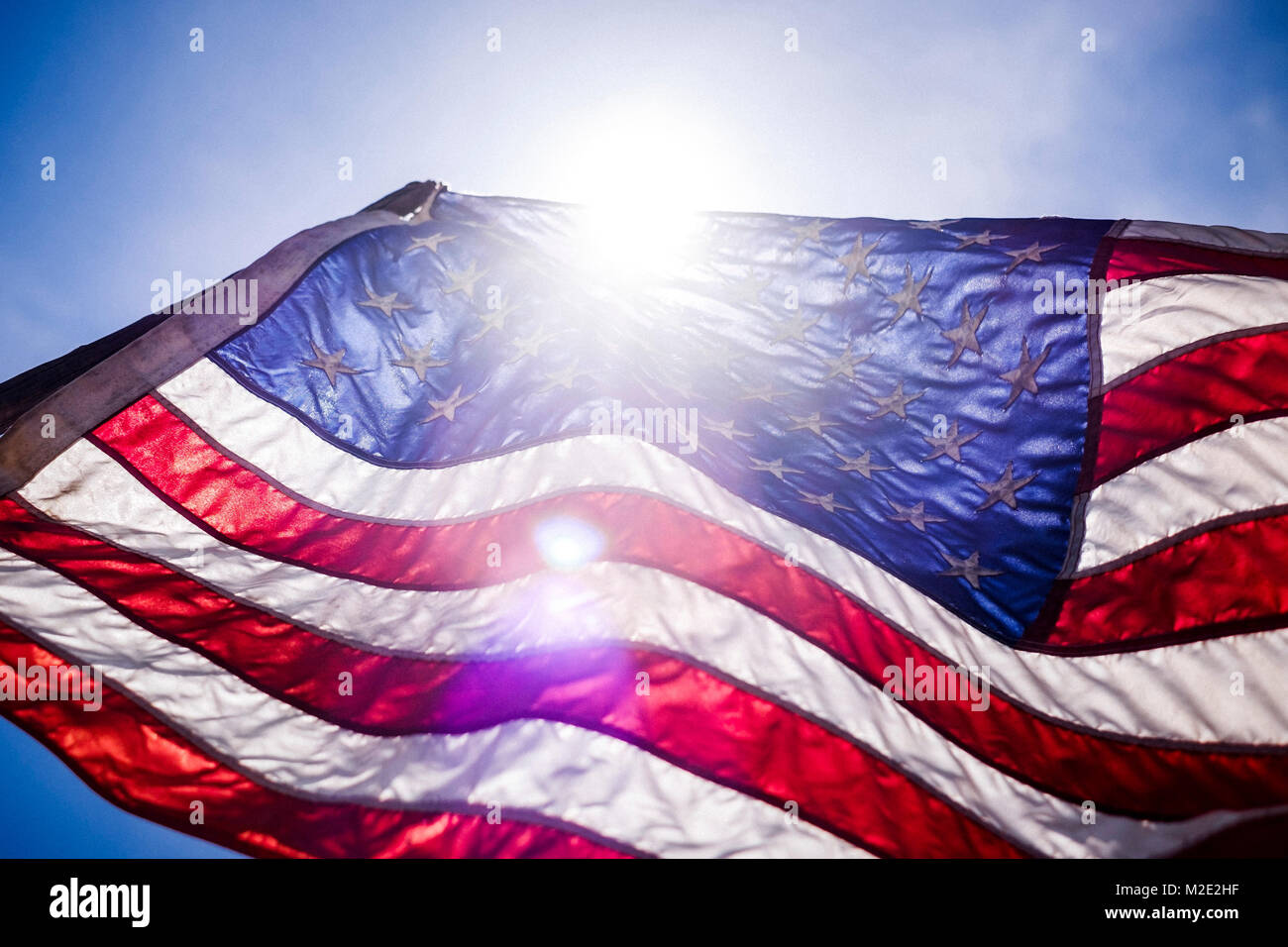 El viento sopla la bandera americana en día soleado Foto de stock