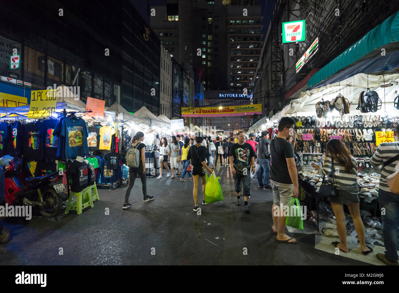 La gente caminando en las luces de un mercado nocturno en Bangkok, Tailandia Foto de stock