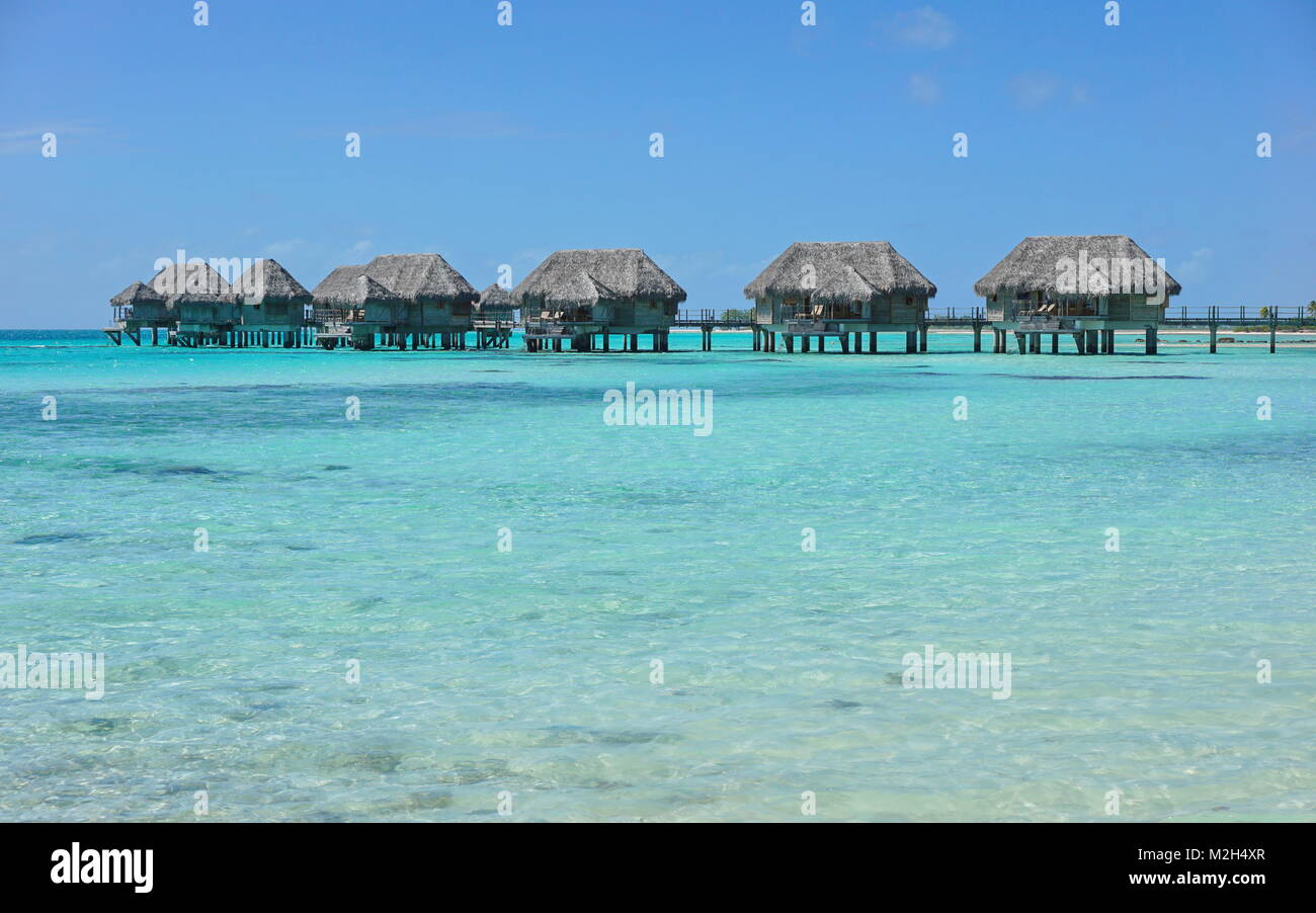 Overwater bungalows tropicales en una laguna de aguas color turquesa, Tikehau atoll, Tuamotus, Polinesia francesa, Océano Pacífico, Oceanía Foto de stock