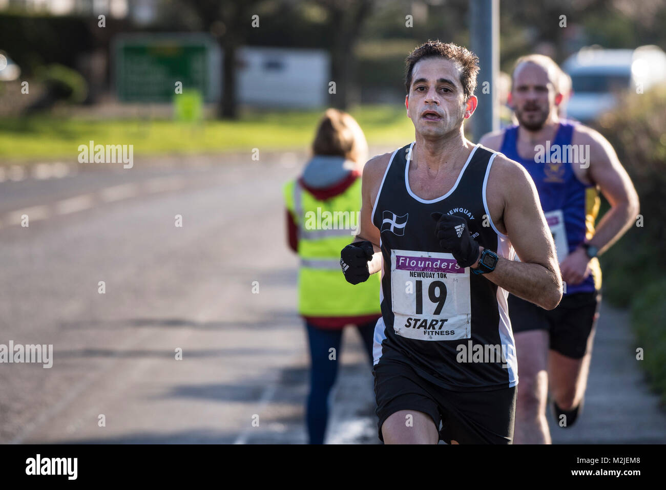 Los corredores compitiendo en una carrera de carretera en Newquay, Cornwall. Foto de stock