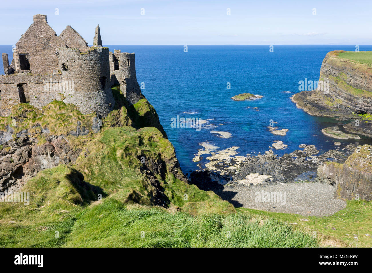 Castillo de Dunluce (irlandés: Dun Libhse), un castillo medieval en ruinas situadas en el borde de un afloramiento de basalto en el Condado de Antrim, Irlanda del Norte Foto de stock