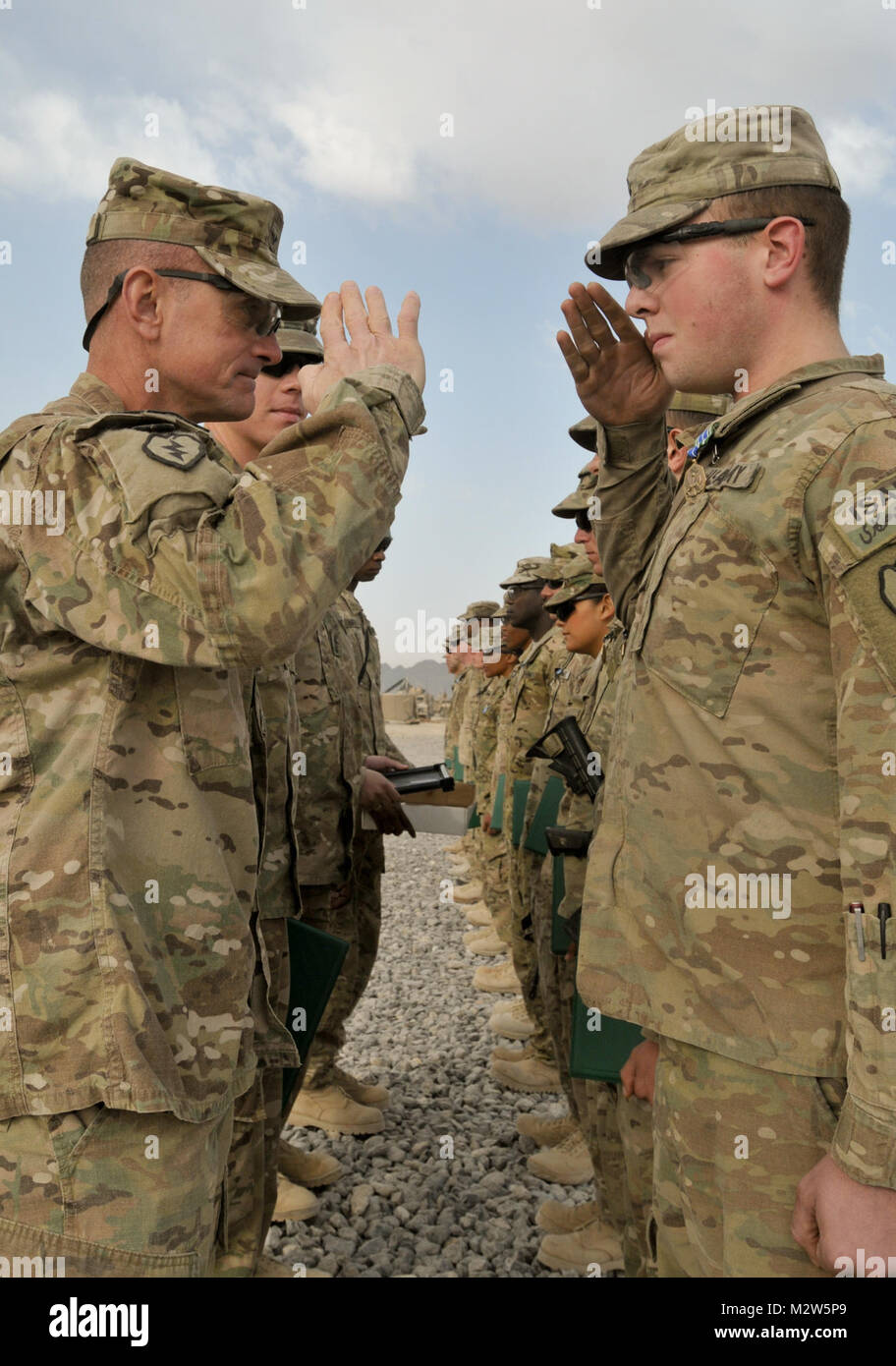 Ejército de EE.UU. PFC. Alex Maxwell, desde Goffstown, N.H., asignados a la Sede y la Sede Compañía, 1er Batallón, 5º Regimiento de Infantería, 1ª Brigada Stryker Combat Team, 25ª División de Infantería, comandante de la brigada saluda el coronel Todd Wood tras adjudicarse la Medalla de Logro del ejército en la base de operaciones de avanzada en Panjwa Shoja'i, distrito de la provincia de Kandahar, Afganistán, 2 de marzo de 2012. 120302-A-GT718-023 por 1 Equipo de Combate de la Brigada Stryker lobos árticos Foto de stock