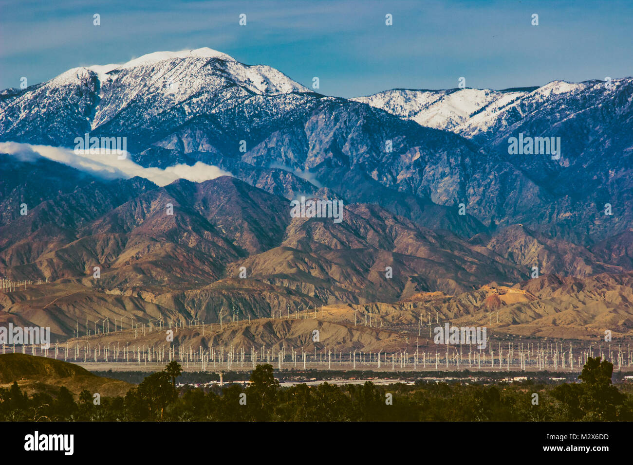 Hermosos nevados Mount San Jacinto se eleva por encima del valle de Coachella y San Gorgonio Pass Wind Farm, Palm Desert, California Foto de stock