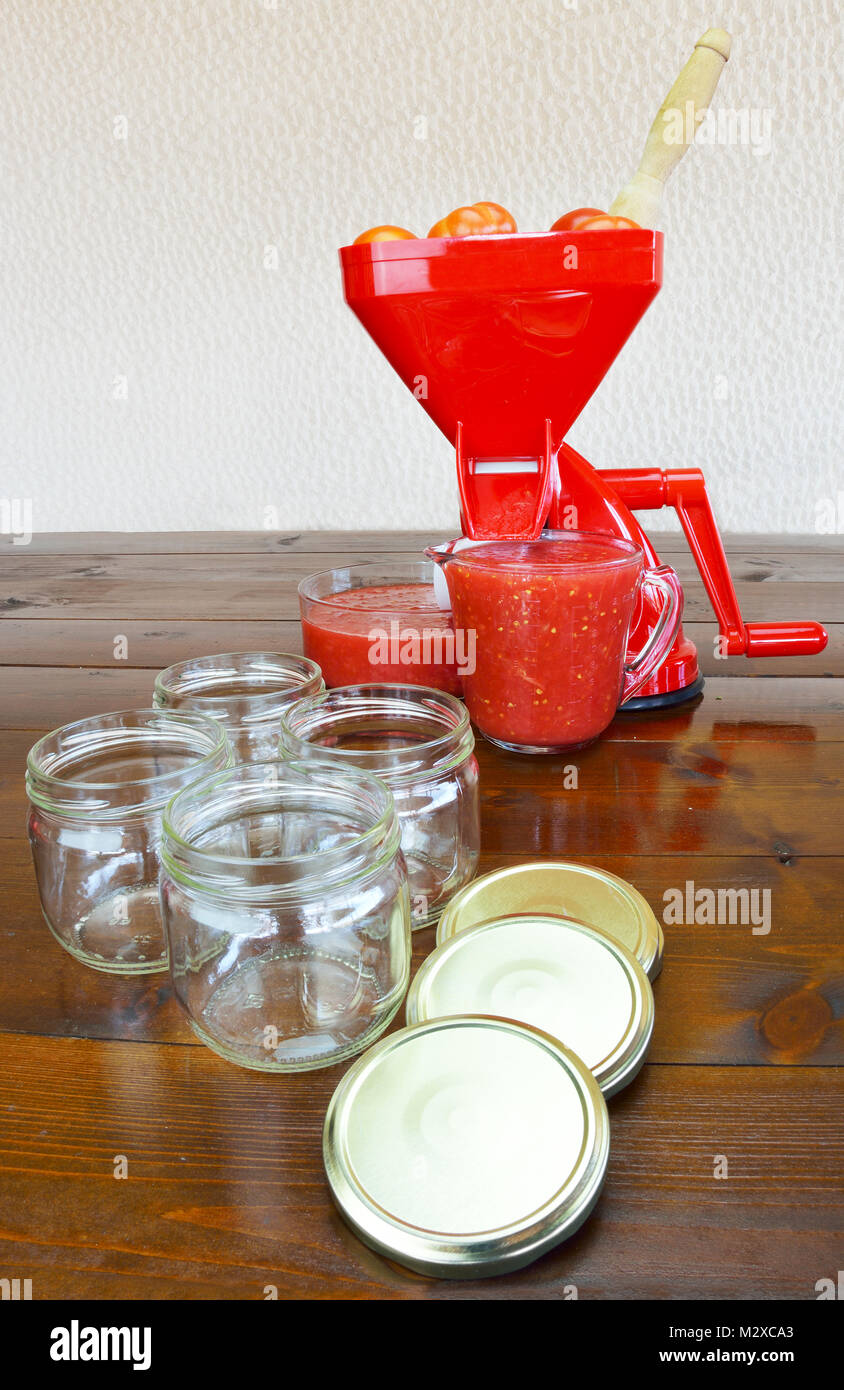 Colador de tomate, salsa de tomate triturado fresco y frascos vacíos  Fotografía de stock - Alamy