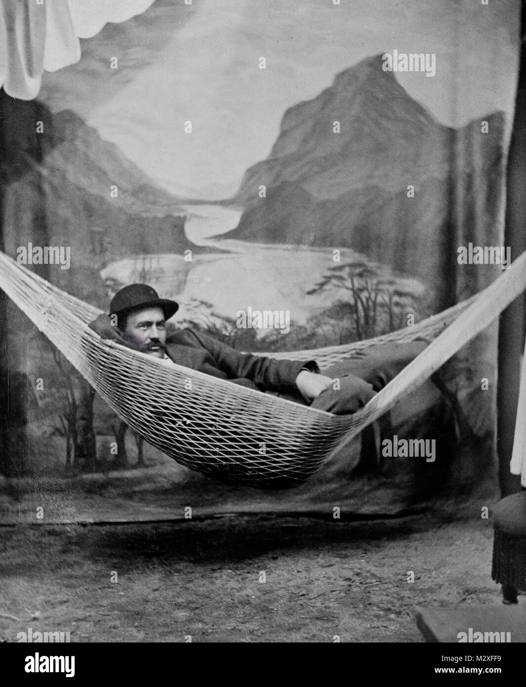 Joven se relaja en una hamaca para studio tintype retrato, ca. 1890. Foto de stock