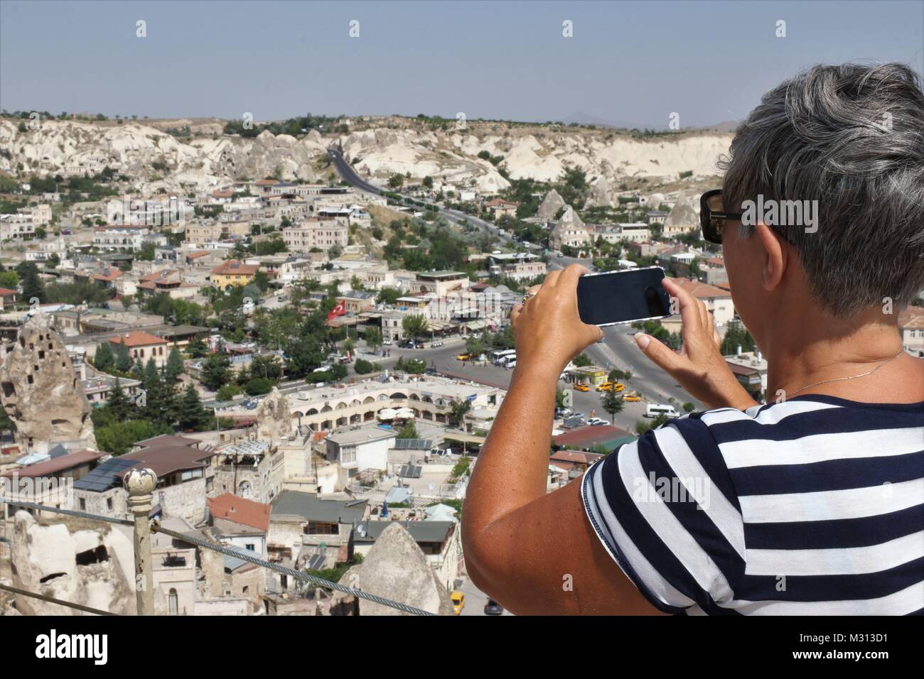 Una señora inglesa turista tomando fotos del impresionante goreme, Capadocia en Turquía Foto de stock