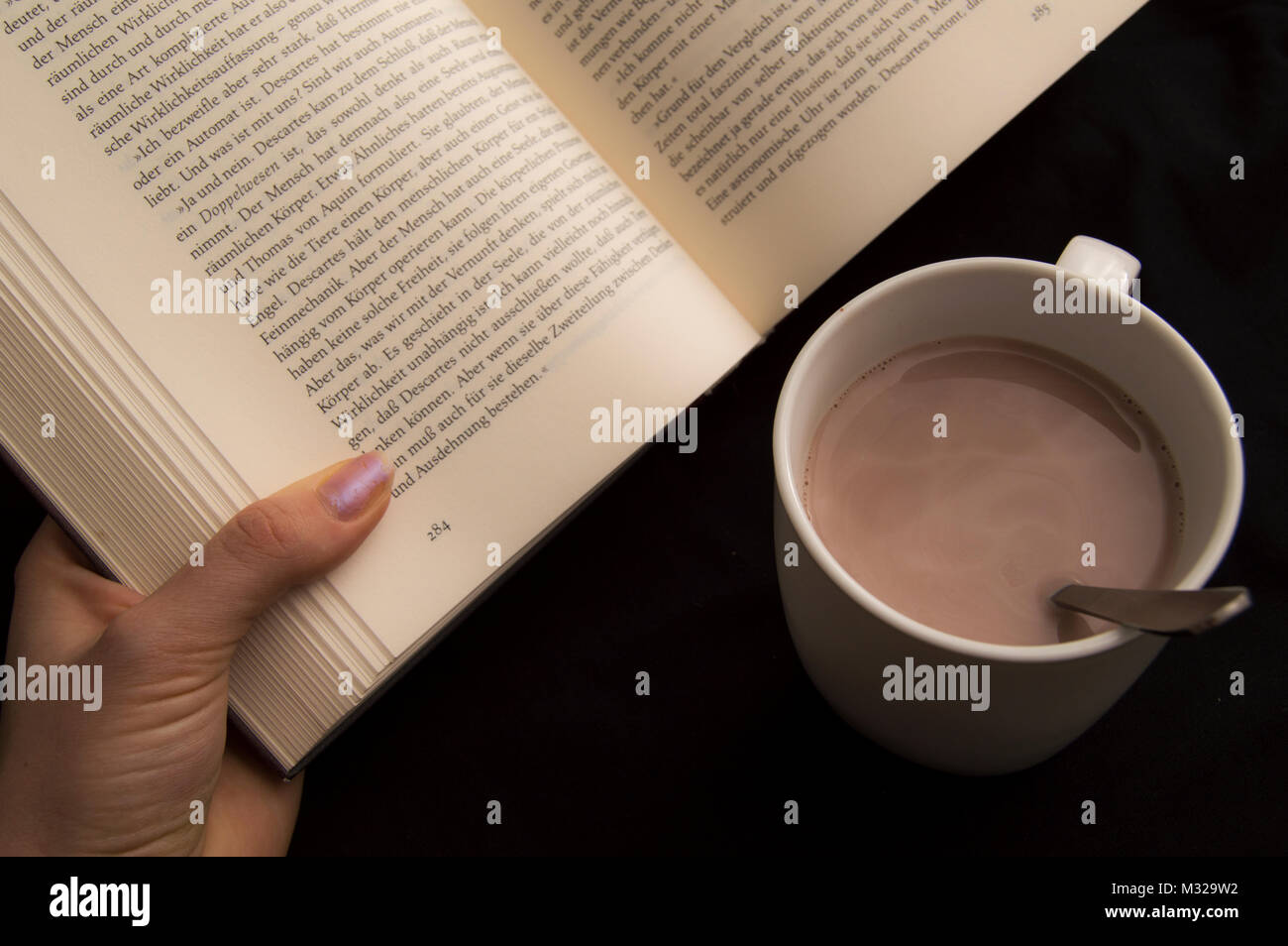 Lectura con chocolate caliente Fotografía de stock - Alamy