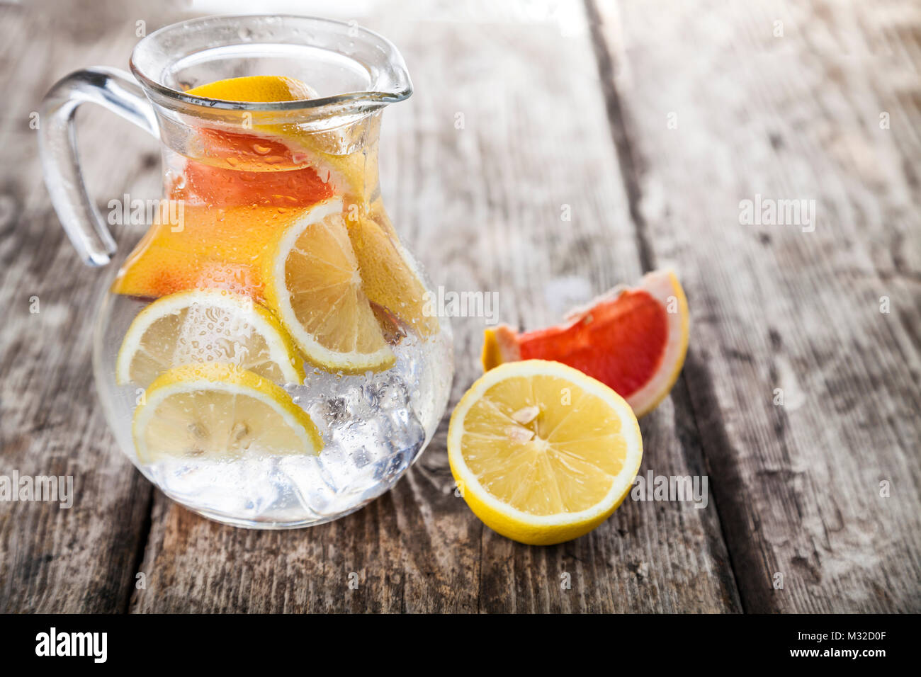 Agua helada refrescante con limón y pomelo, sobre un fondo de madera. Concepto de dieta. Dieta para la pérdida de peso. Foto de stock