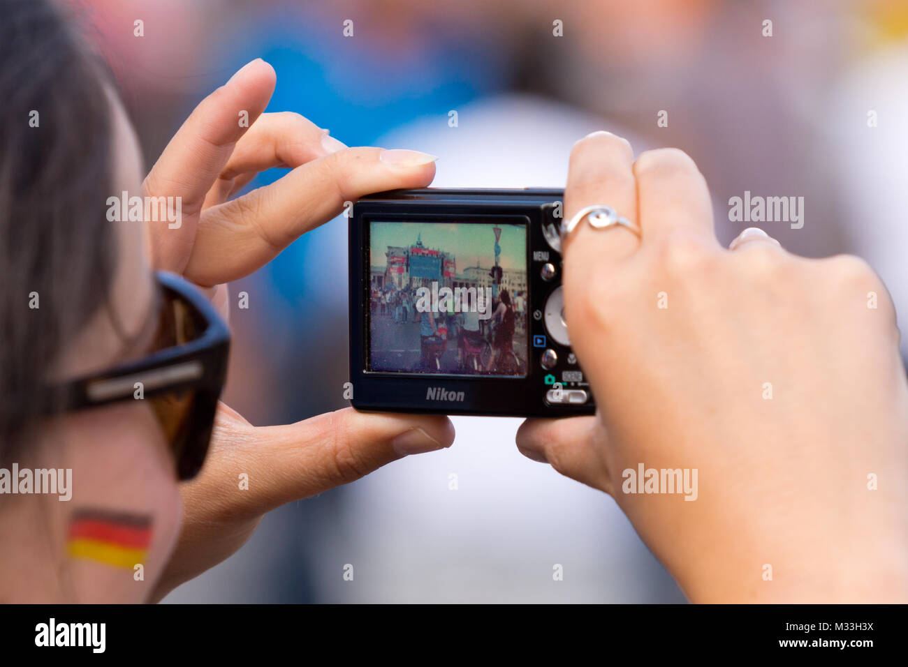Frau mit Fotoapparat digitalen auf der Fanmeile zur Europameisterschaft 2012 Deutschland gegen Griechenland am Brandenburger Tor en Berlín. Foto de stock
