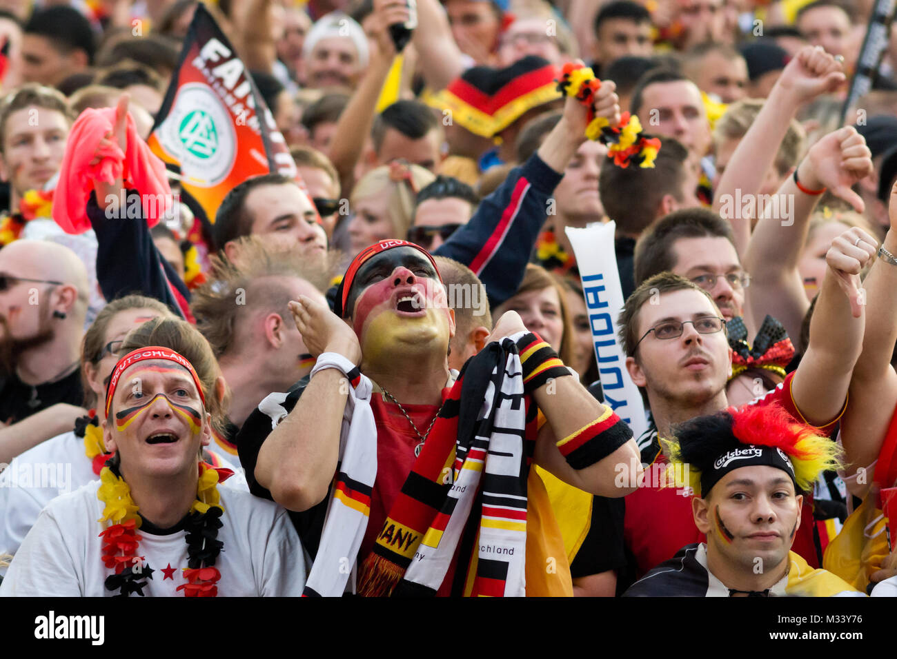 Menschenmassen verfolgen auf der riesigen Leinwand und freuen sich auf derFanmeile zur Europameisterschaft 2012 Deutschland gegen Griechenland am Brandenburger Tor en Berlín. Foto de stock