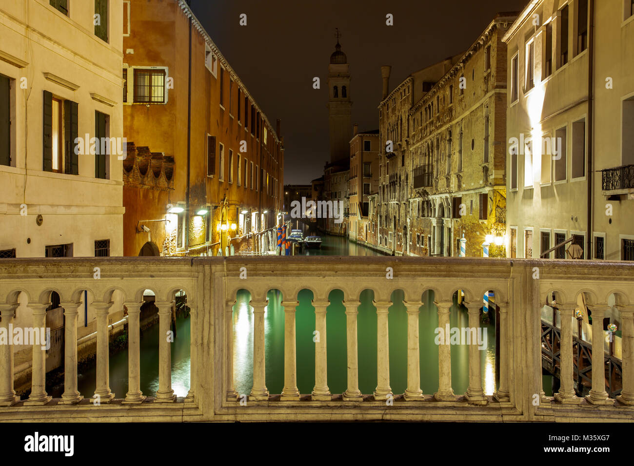 Canal pequeño en la laguna de Venecia, ciudad en la noche. La larga exposición Venezia hidrovías Italia Foto de stock