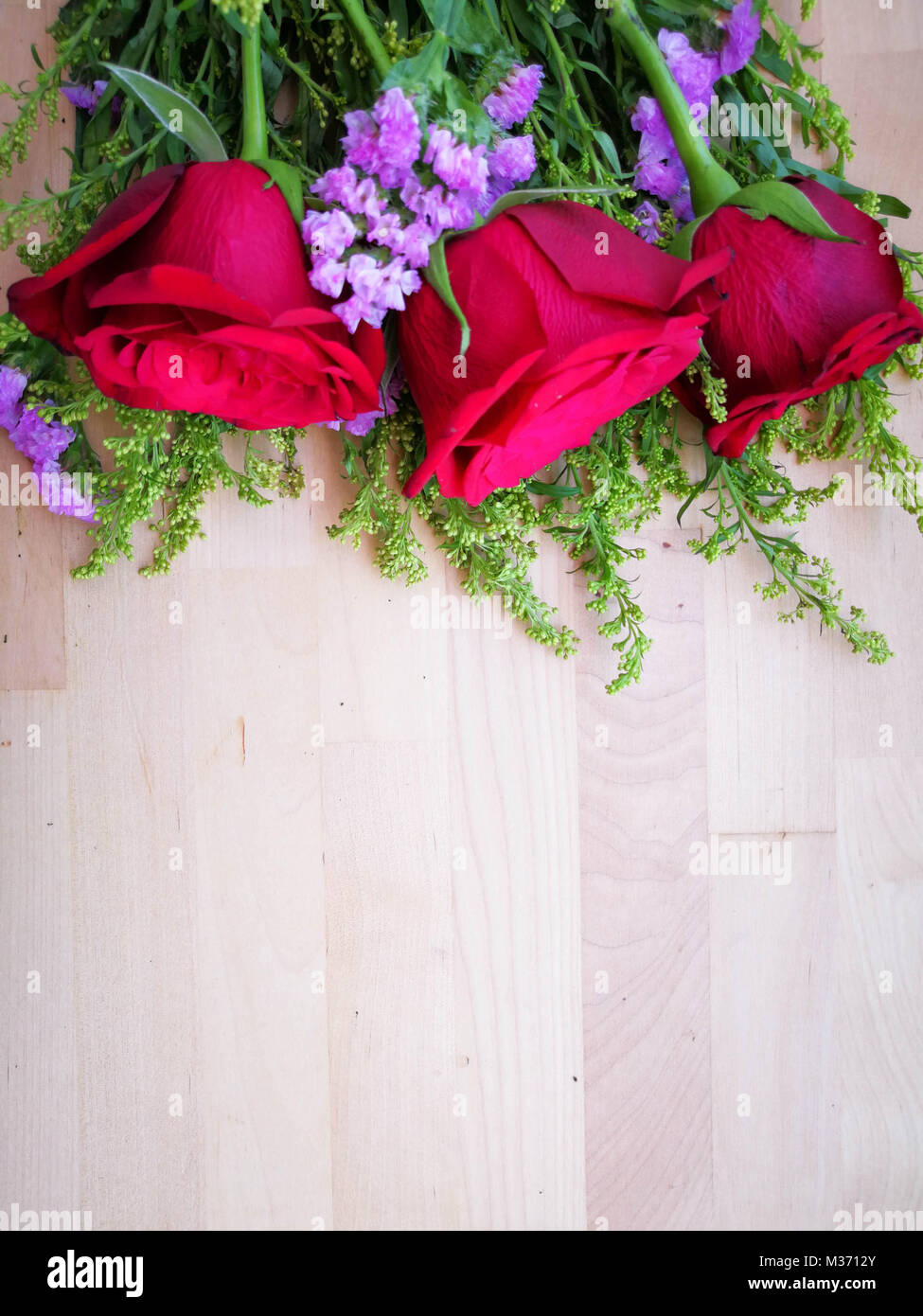 Bouquet de rosas rojas sobre fondo de madera. Concepto de Día de San