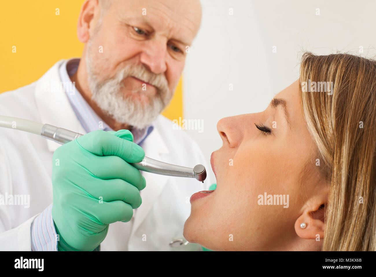 Macho maduro dentista con taladro dental en paciente de sexo femenino -  Tratamiento de Caries dental Fotografía de stock - Alamy
