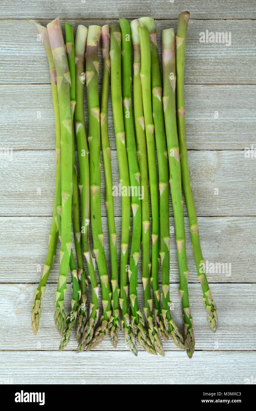 Espárragos frescos recogidos sobre fondo rústico en formato vertical