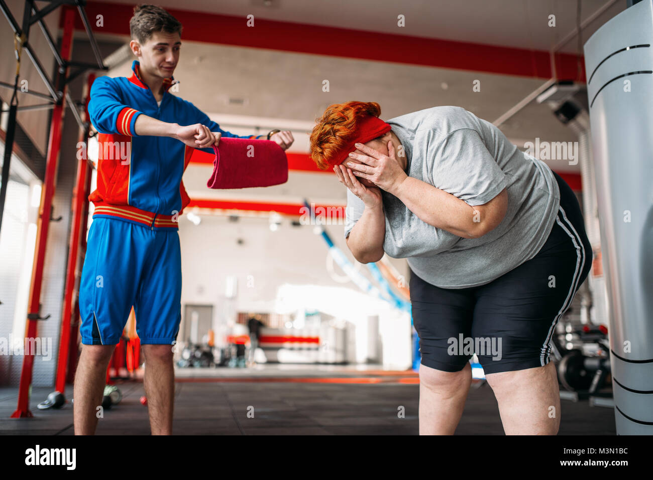 Fuerzas formador sobrepeso mujer al ejercicio, duro ejercicio en el gimnasio Foto