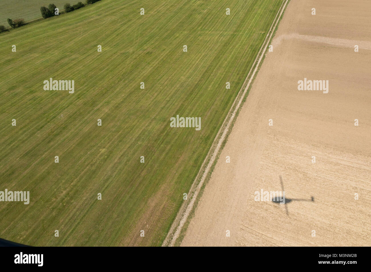 Vista aérea de campo con sombra de helicóptero procedente en tierra cerca del aeropuerto Jesenwang Flugplatz, Baviera, Alemania Foto de stock