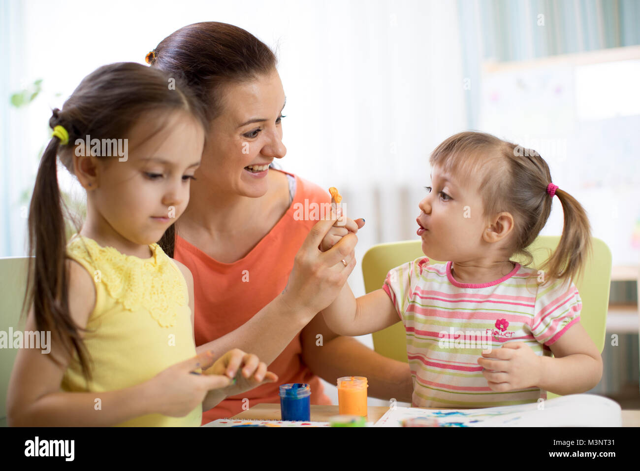 Los niños y la madre con pinturas de dedos Foto de stock