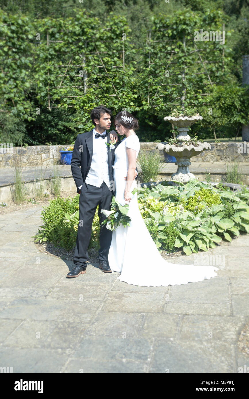 Hermosa morenaza la novia y el novio en una boda de estilo tradicional vestido blanco/traje negro- Decoración Art Deco- día soleado Foto de stock