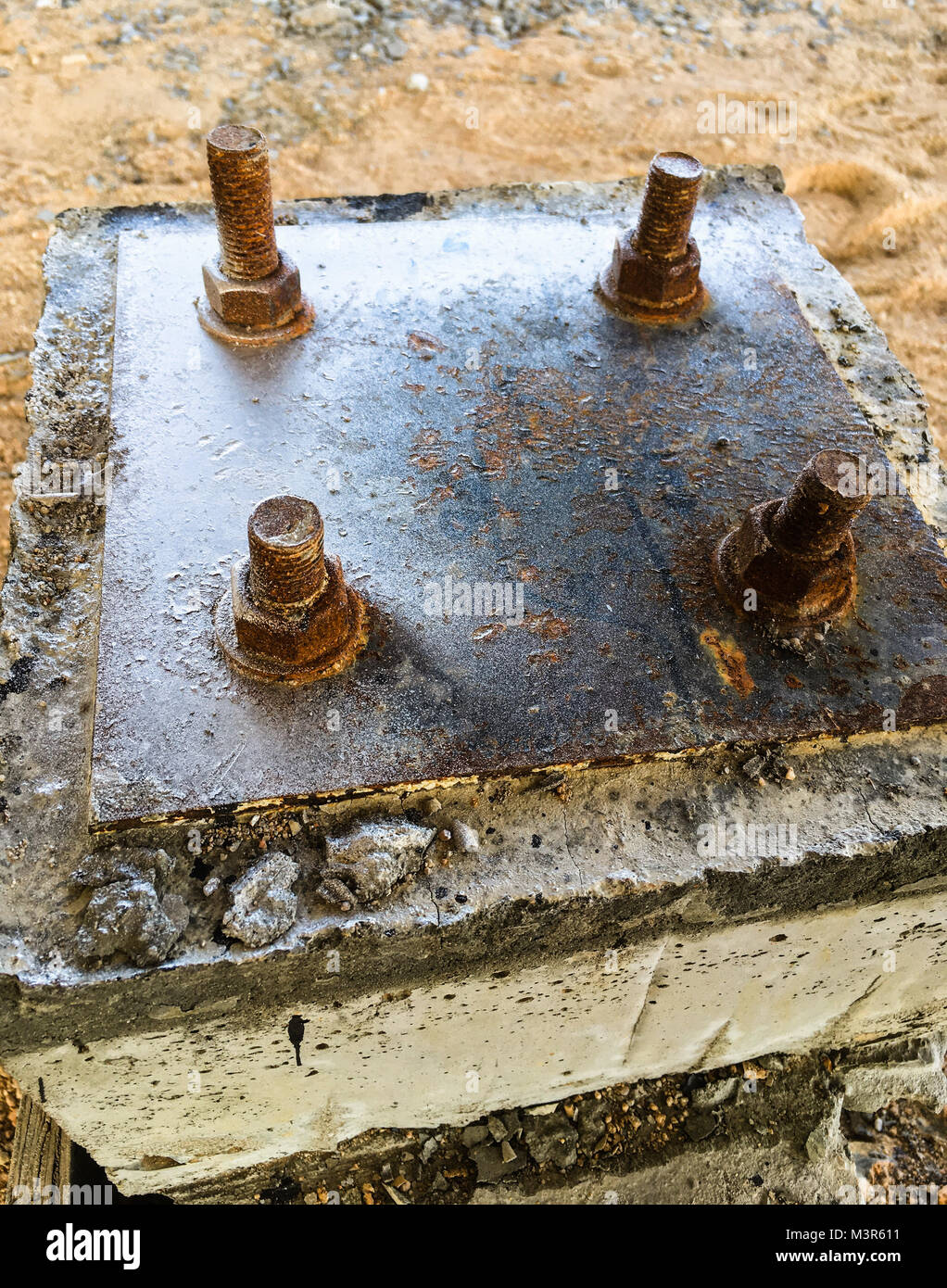 La placa de acero sobre la base de los tornillos de anclaje en el pilar de hormigón. Foto de stock