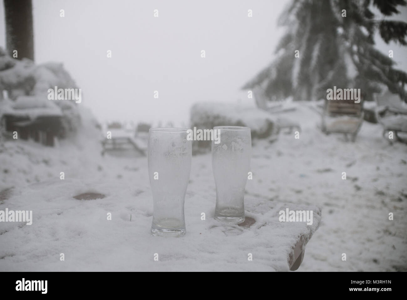 Cerca de dos vasos de cerveza vacías en la nieve. Foto de stock