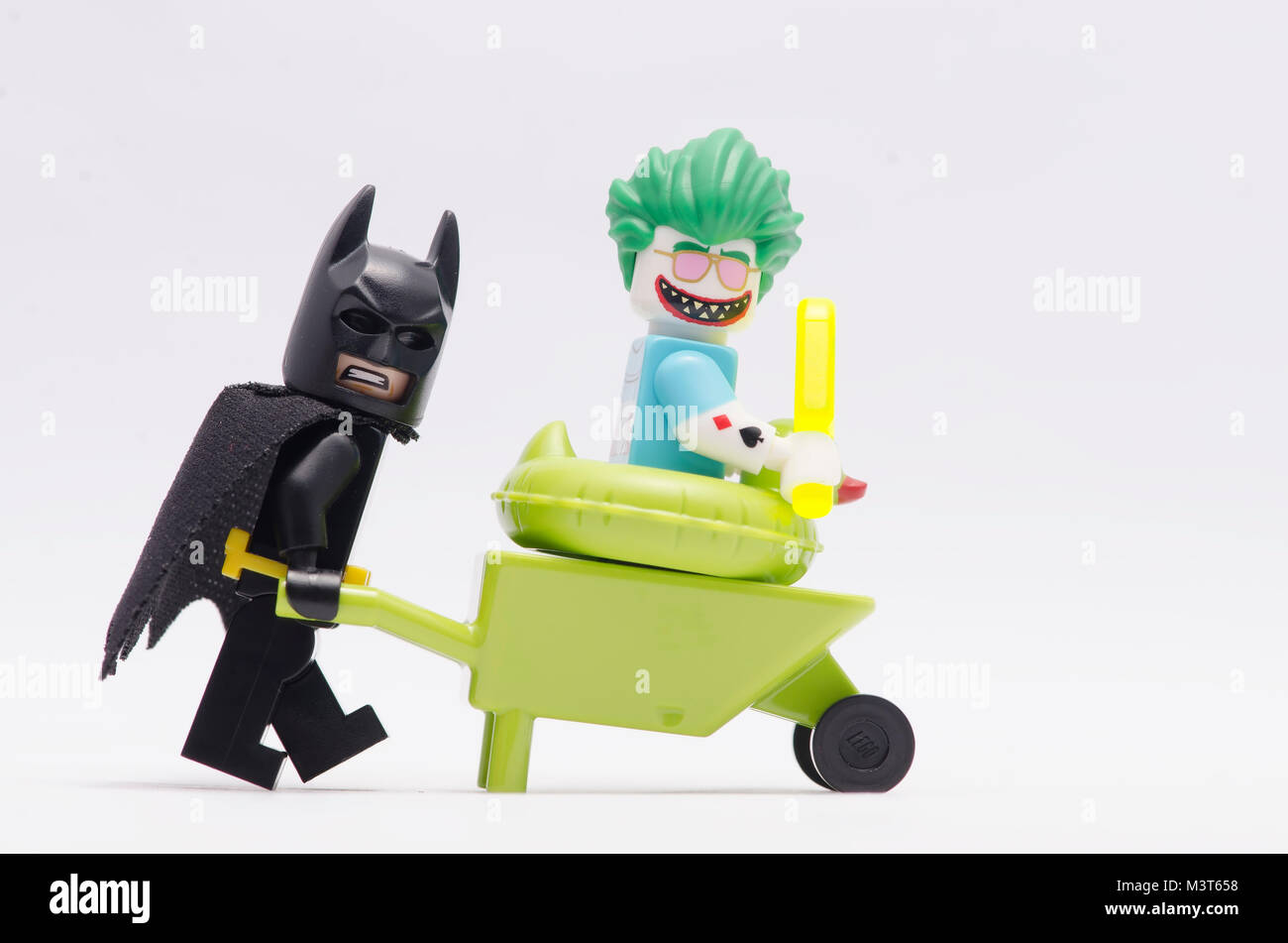 Lego Batman empujando la carretilla de mano mientras joker sentado en él.  aislado sobre fondo blanco Fotografía de stock - Alamy