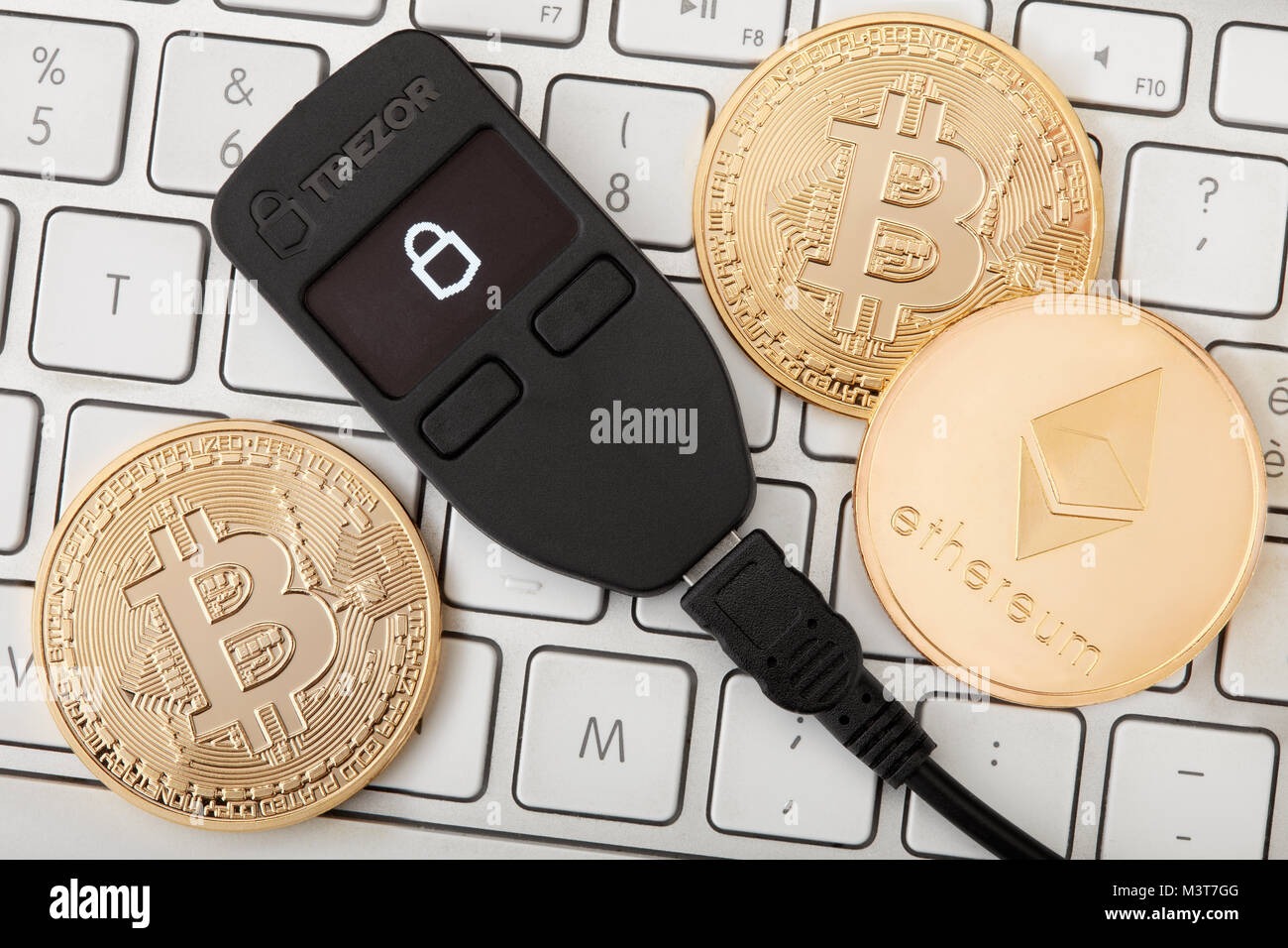 Monedero de cryptocurrency Trezor hardware de con oro y monedas bitcoin ethereum Fotografía de stock - Alamy