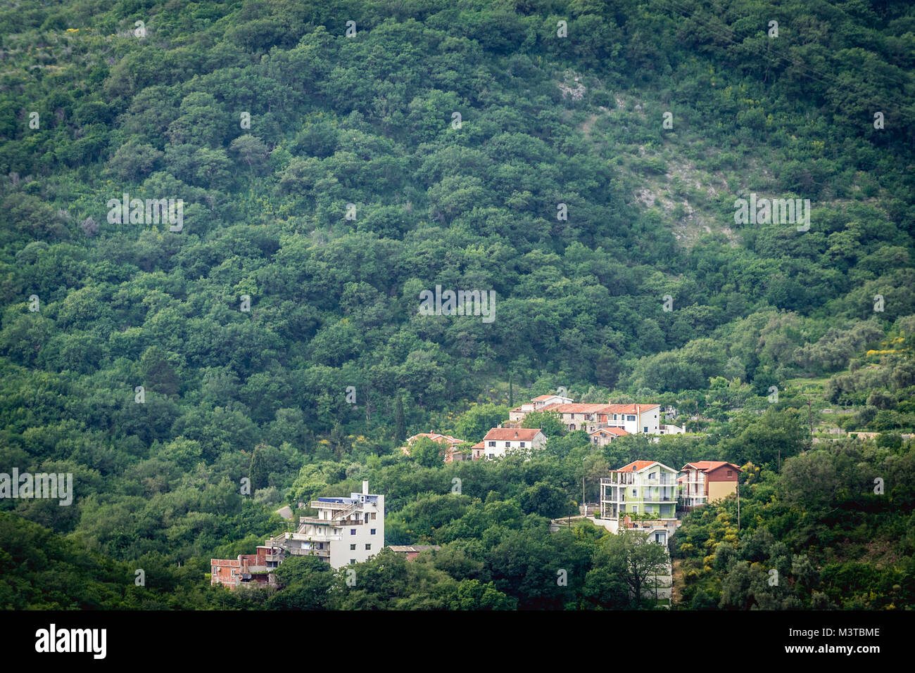 Houes en la ladera de la montaña cerca de Petrovac na Moru ciudad en Montenegro Foto de stock