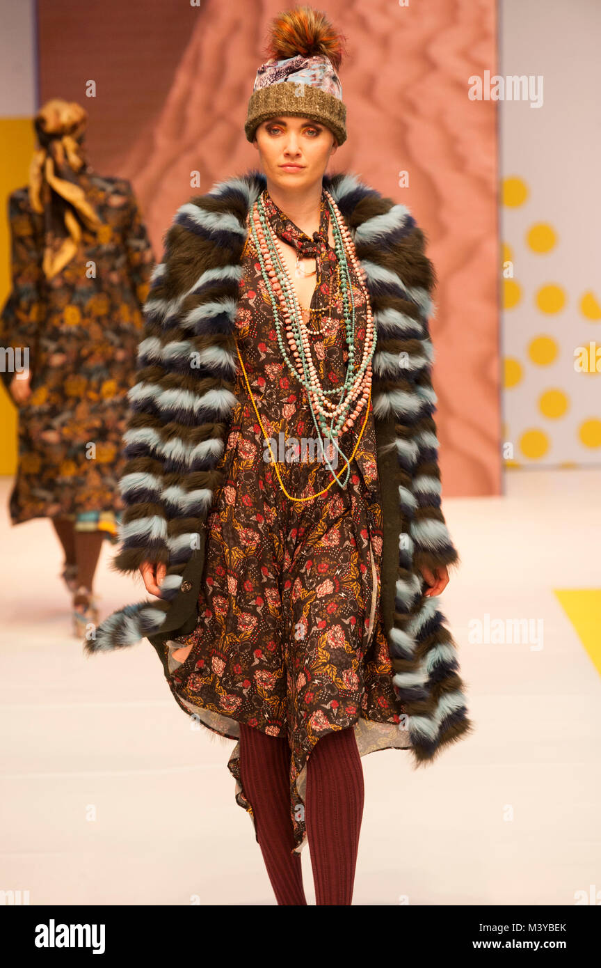 Modelo de pasarela de moda en Londres puro/W 2018/19, Olympia, Londres, Reino Unido. Modelo lleva abrigo por Etherion y vestido Heach por. Collares de fantasía por fantasía. Pure London es