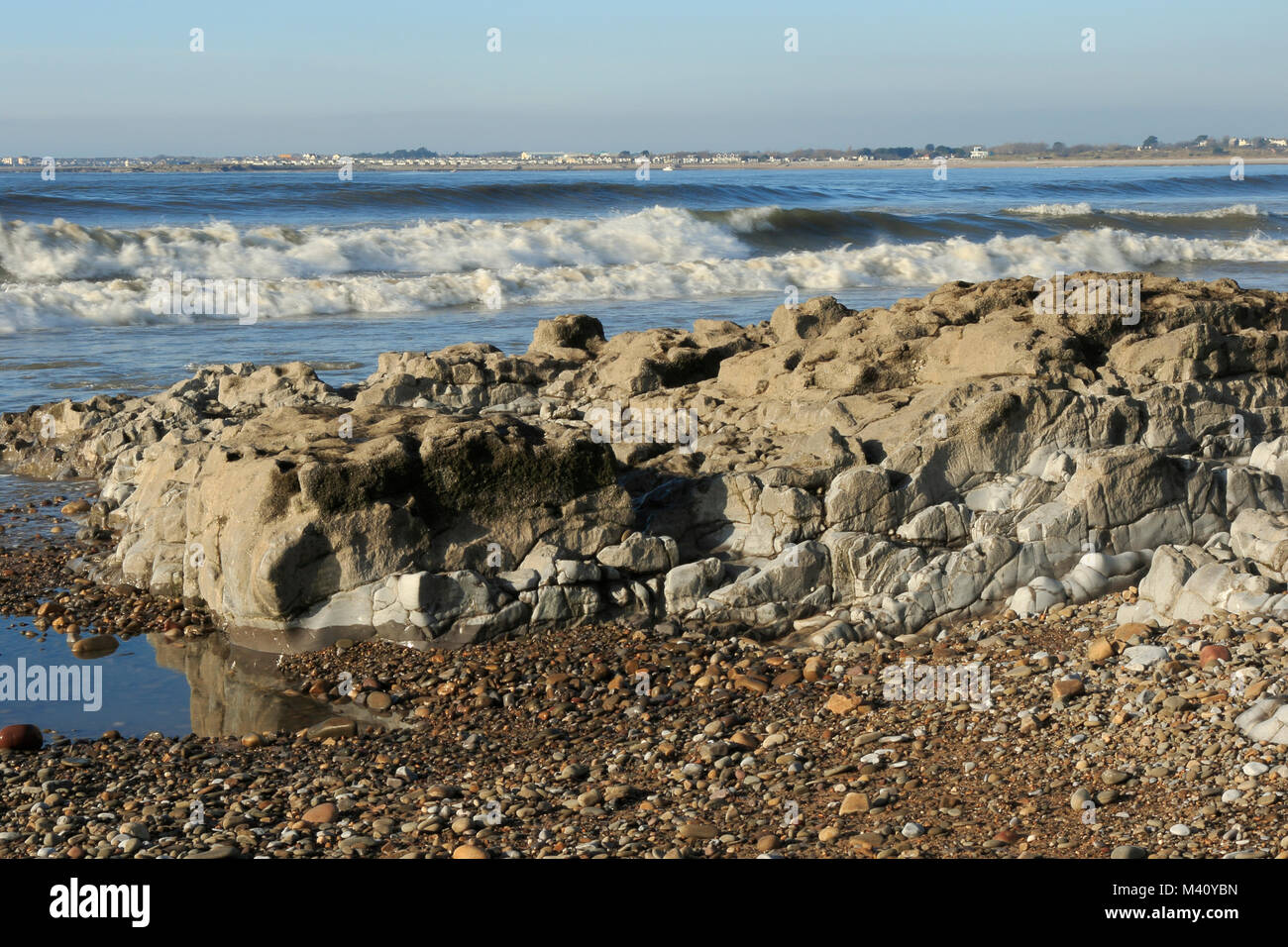 Ogmore por mar, muestra las formaciones rocosas y las olas. Porthcawl puede ser visto en la distancia. South Wales UK Foto de stock