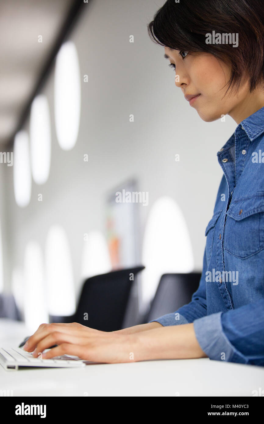 La empresaria asiática escribiendo en un teclado Foto de stock