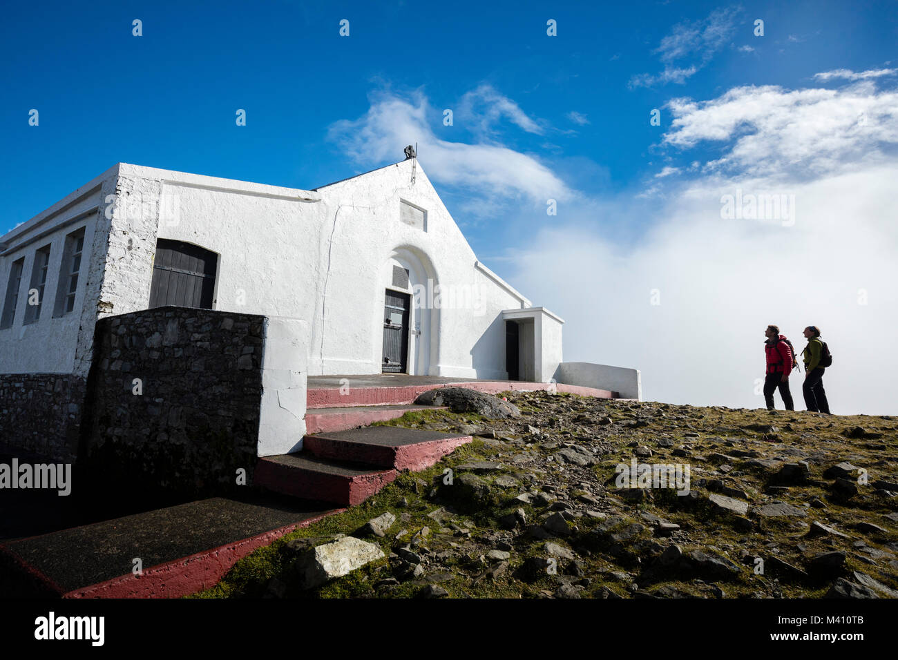Caminantes besite la iglesia en la cumbre de Croagh Patrick, en el condado de Mayo, Irlanda. Foto de stock