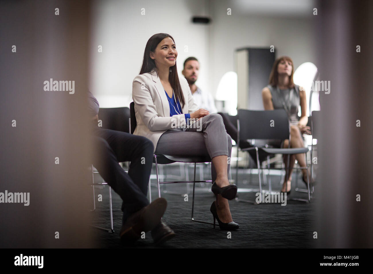 Ejecutivo femenino escuchando en una conferencia de negocios Foto de stock