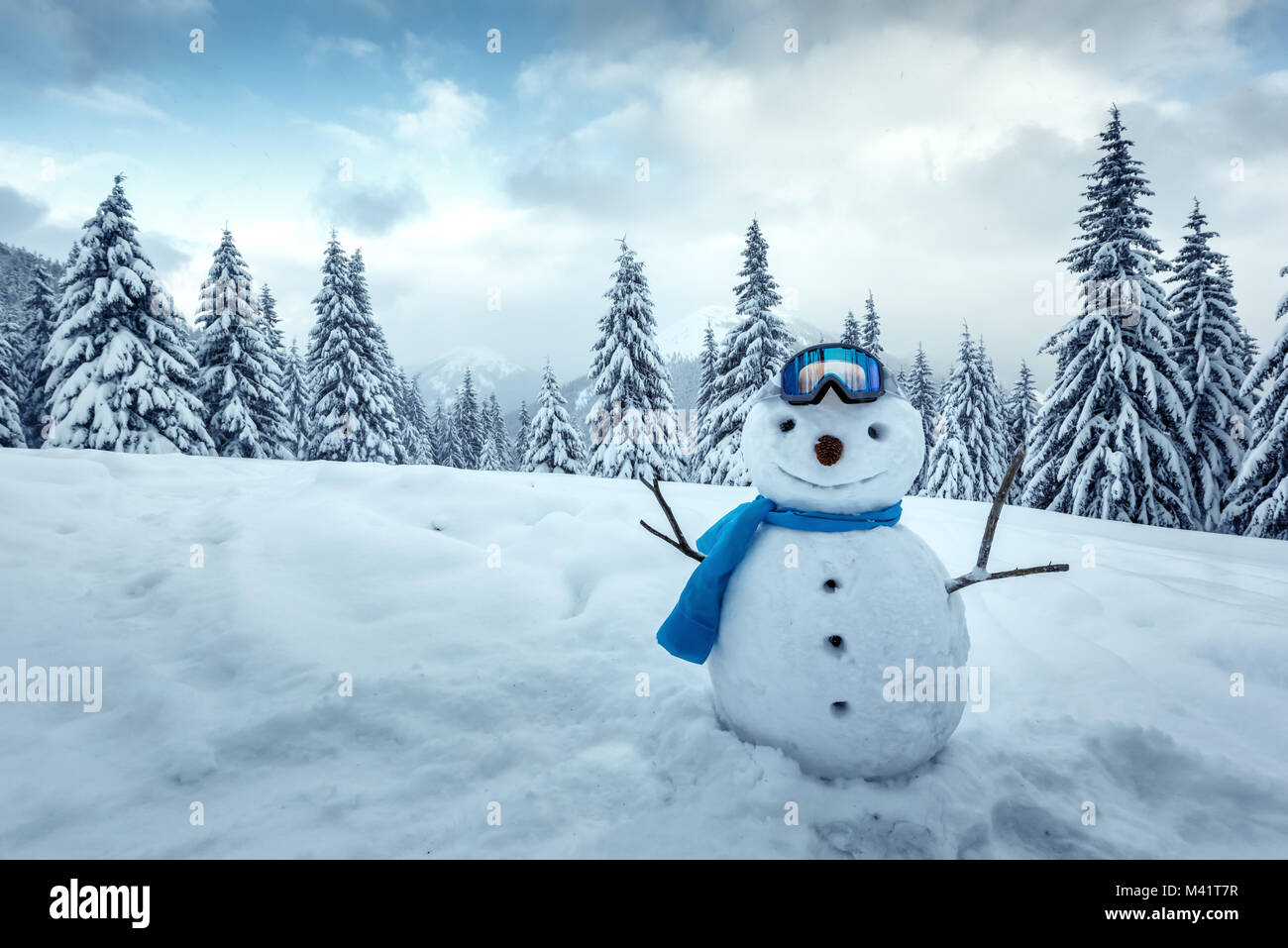Gracioso muñeco de nieve en el cristal de esquí Foto de stock