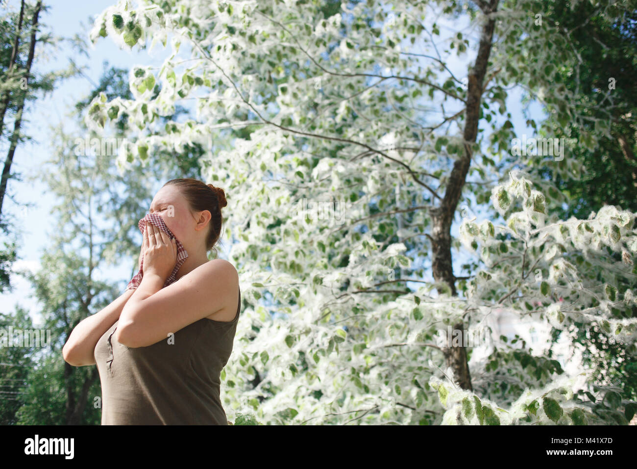 Mujer joven que sufren alergia al polen de primavera. Álamos temporada Bloom Foto de stock