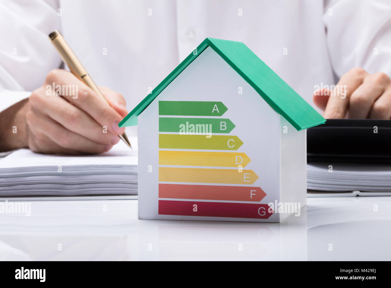 Parte media del empresario calcular la factura con el uso eficiente de la energía en la casa modelo gráfico de Office Foto de stock