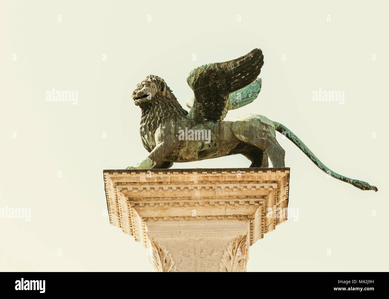 Venecia, Provincia de Venecia, Región de Véneto, Italia. El león alado de Venecia de bronce de pie en la cima de la columna de granito en la Piazzetta off Piazza San Marco Foto de stock