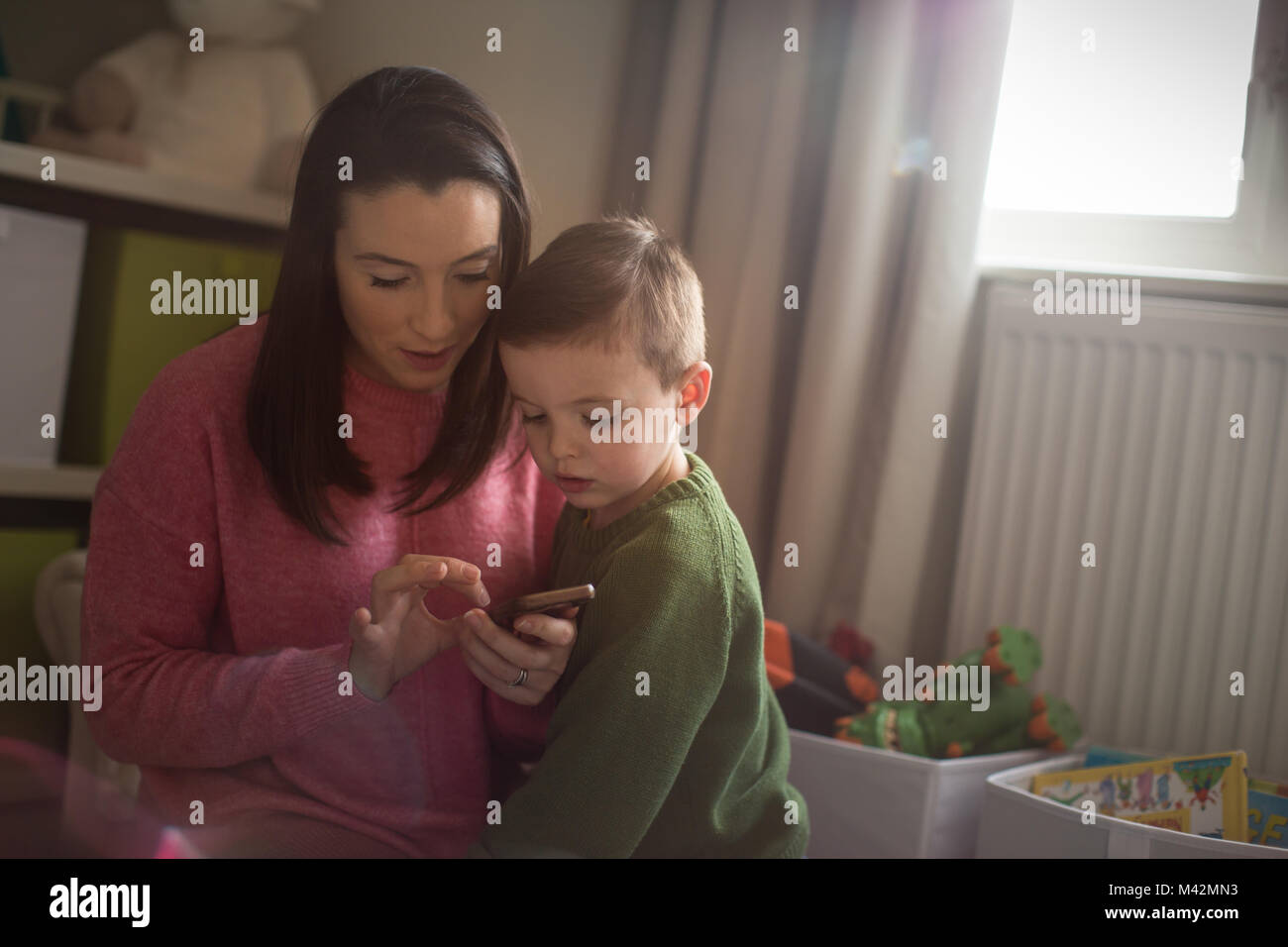 Madre e hijo mirando el smartphone Foto de stock