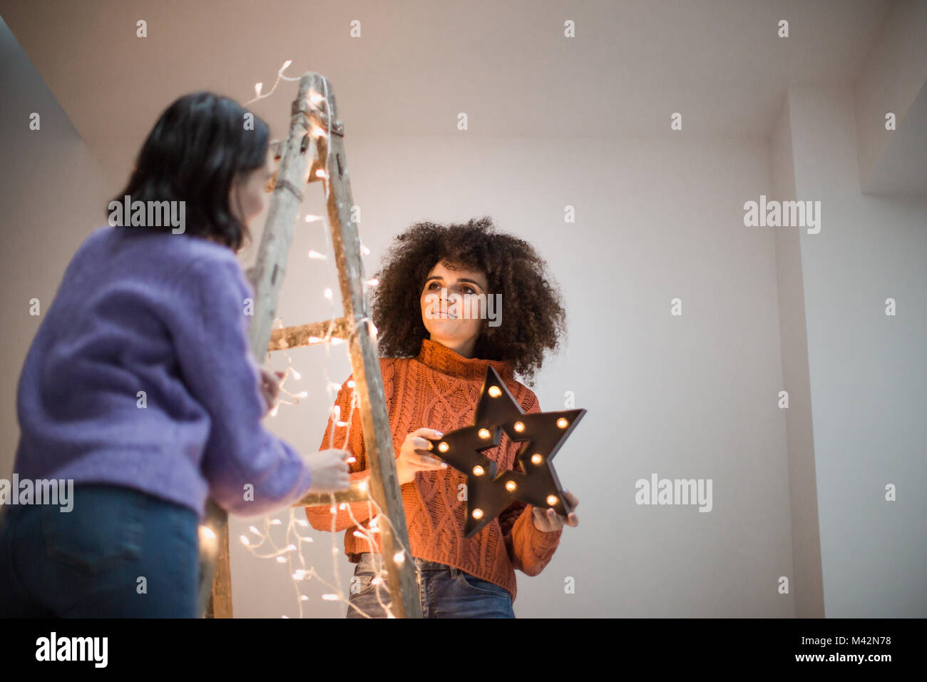 Amigos Decorar un árbol de navidad alternativo Foto de stock