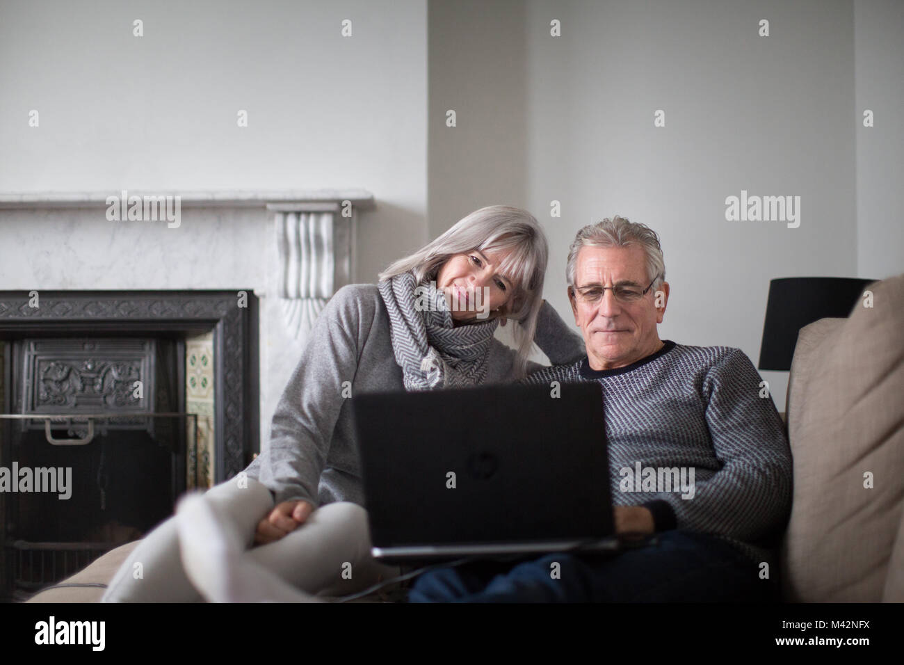 Las parejas ancianas en casa utilizando un ordenador portátil Foto de stock